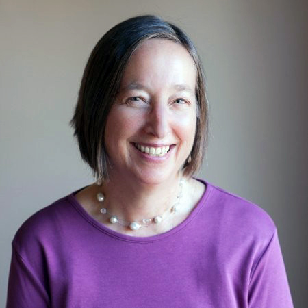 Smiling woman with purple sweater.