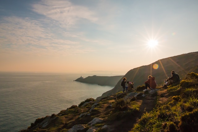 Utsiktsbilde med mennesker som ser utover havet i solnedgang