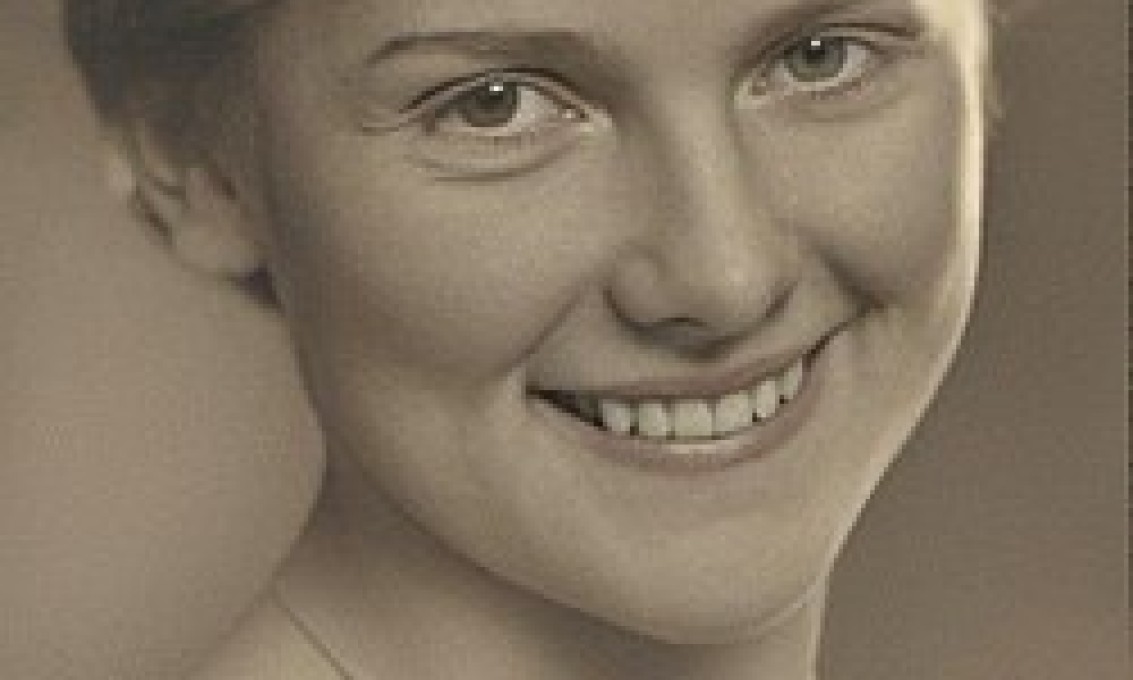 svart-hvitt bilde av smilende kvinne som ser i kamera