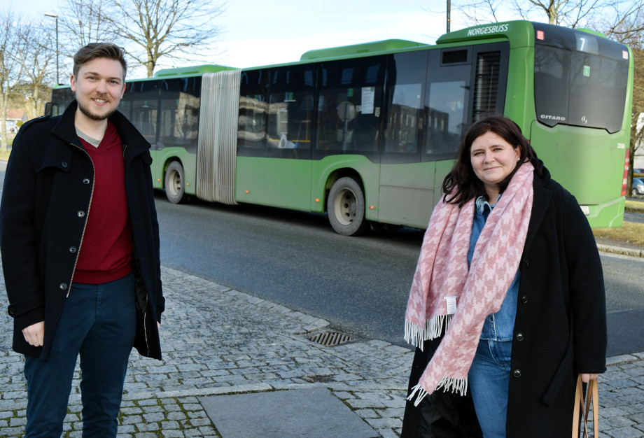 To studenter utenfor Arne Rettedals hus, med en rutebuss i bakgrunnen.