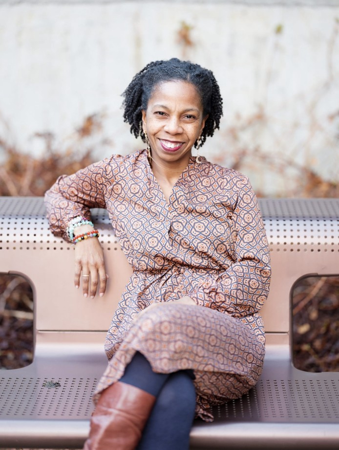 Nafeesa sitting on a bench outdorrs, smiling