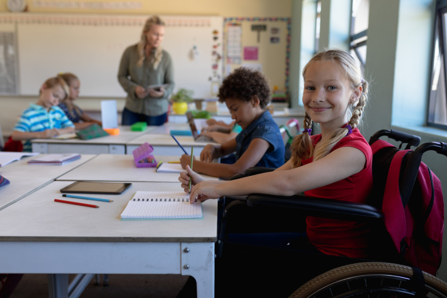 Elev sitter ved pult på skole