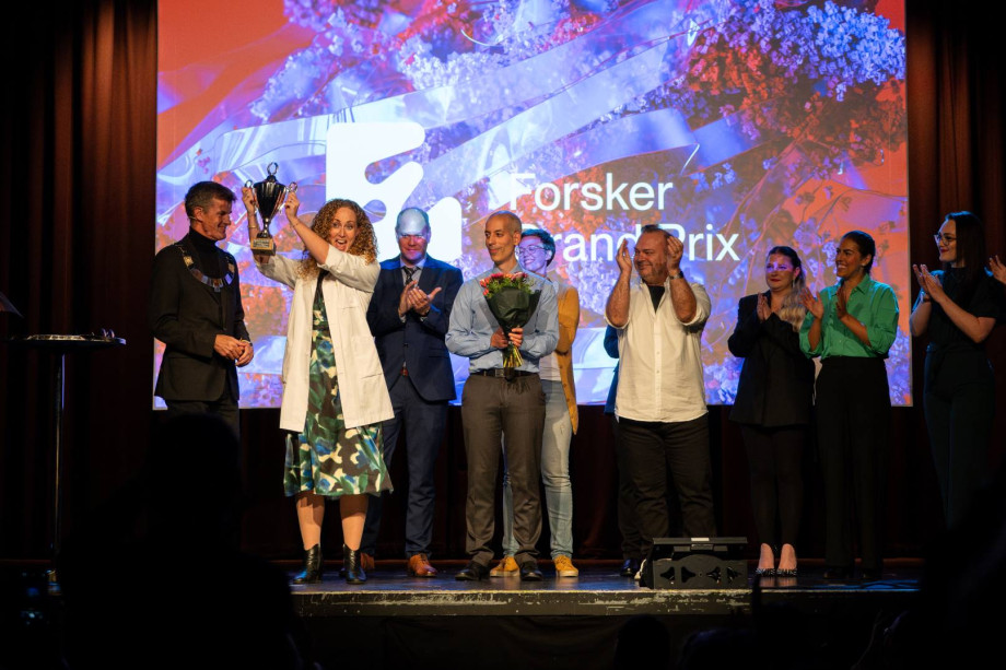 Flere folk på scenen. En holder en pokal. 